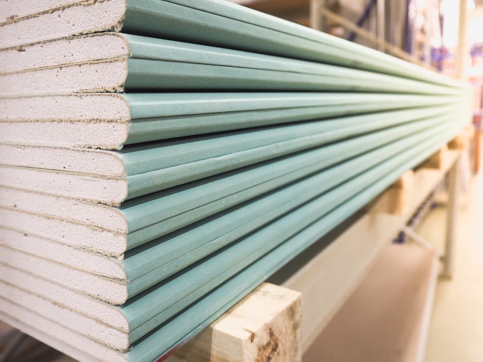 Intérieur d'entrepôt de matériaux de construction avec plaques de plâtre empilées sur palette en bois